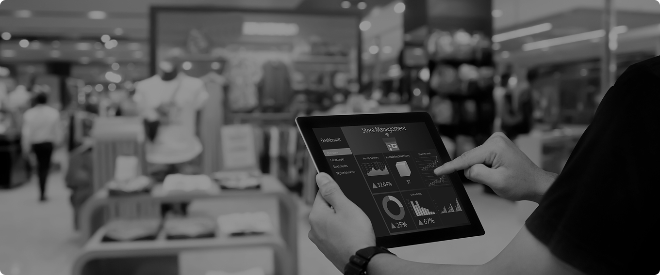 Retail manager using store analytics dashboard on tablet showing real-time business intelligence and operational metrics